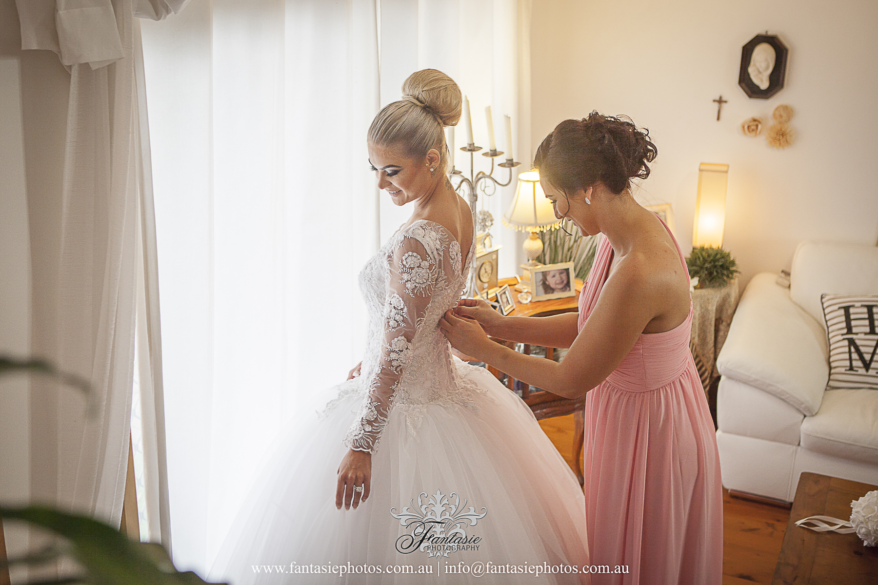 Beautiful bride and maid of honor getting ready at home