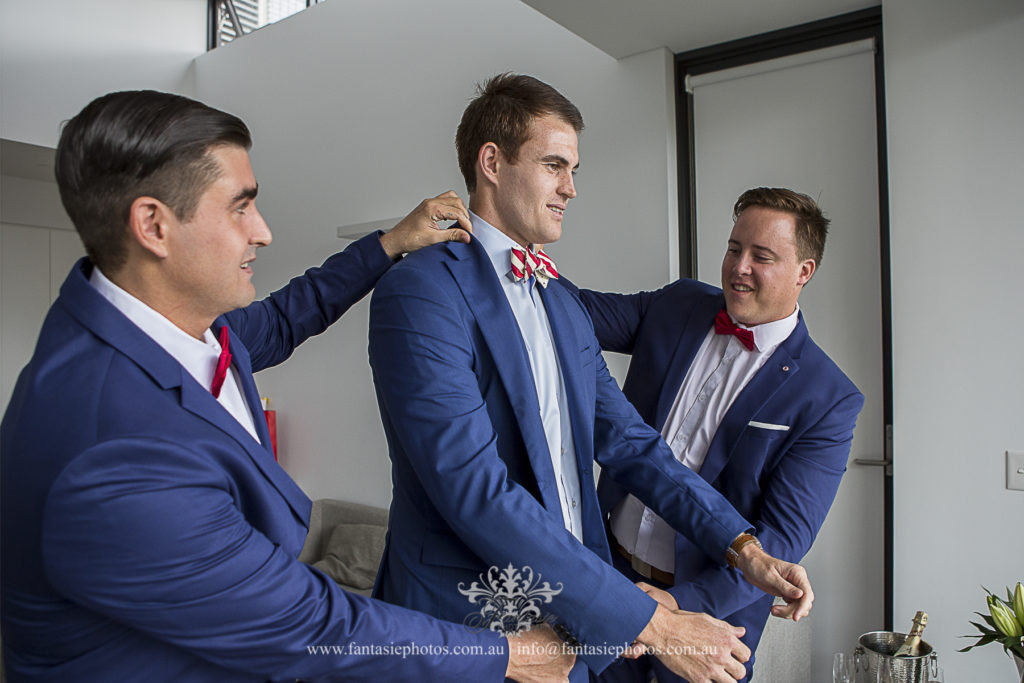 Groomsmen getting ready for groom at home Lindfield