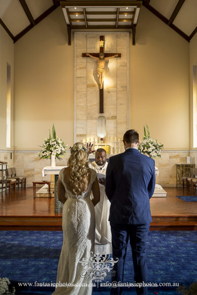 Bride and groom vowing in front of priest